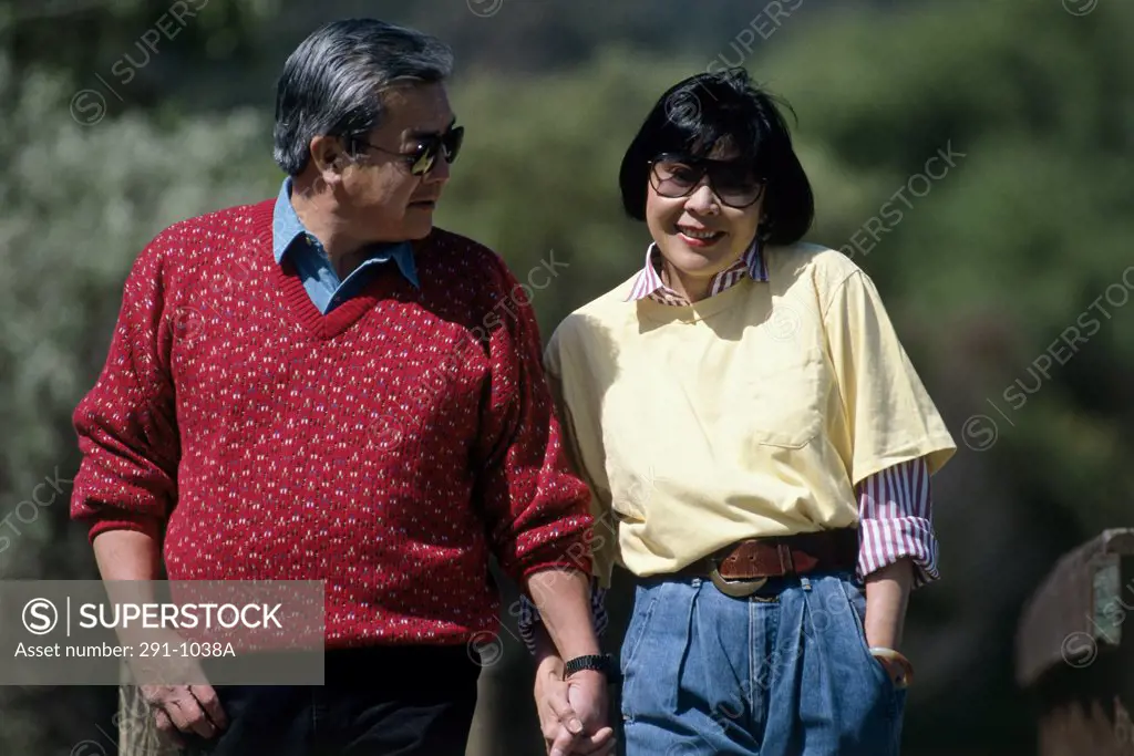 Mid adult couple holding hands and walking