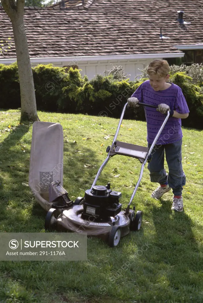 Boy mowing the lawn with a lawn mower