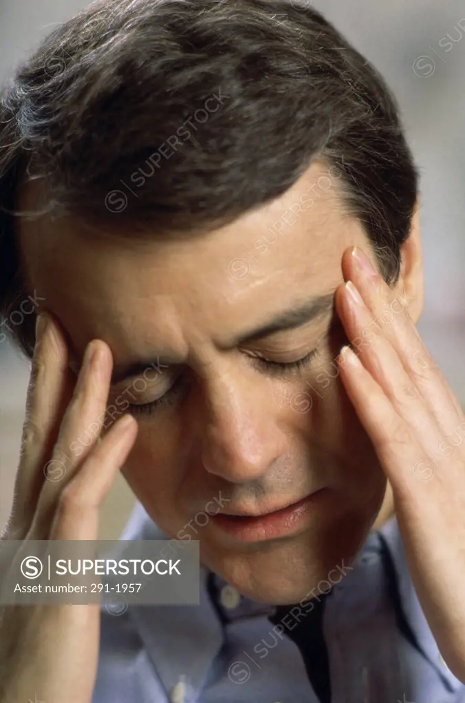 Close-up of a mid adult man suffering from a headache