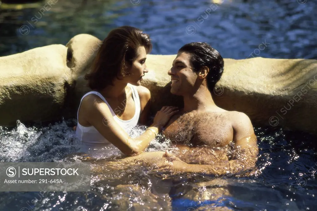 Young couple in a hot tub and smiling