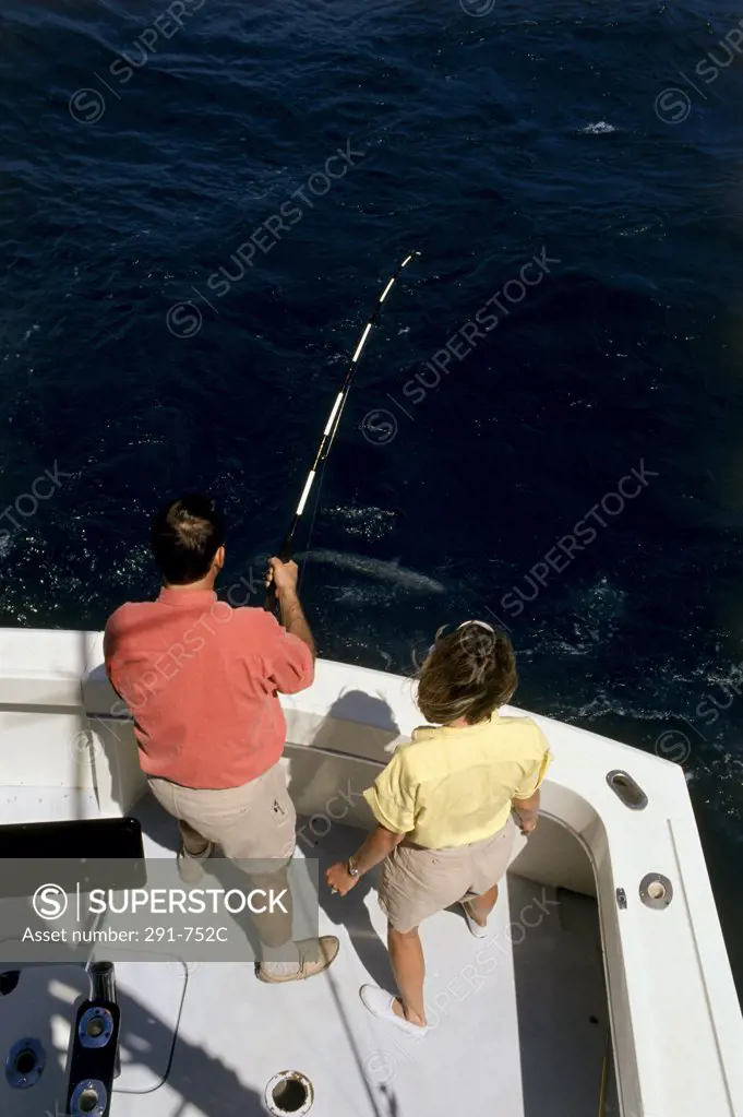 High angle view of a young couple fishing in the sea
