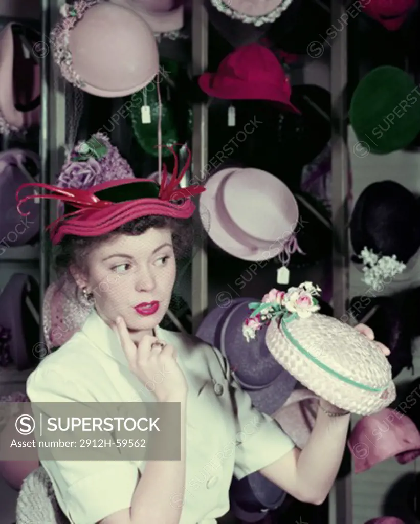 Woman in 1950's trying on different hats