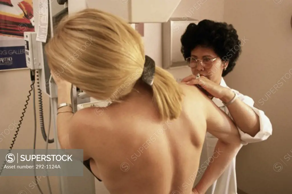 Female doctor preparing a patient for a mammogram