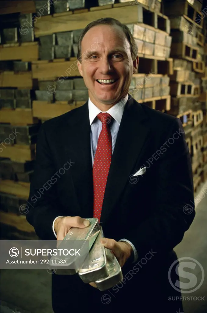 Businessman holding silver bars and smiling