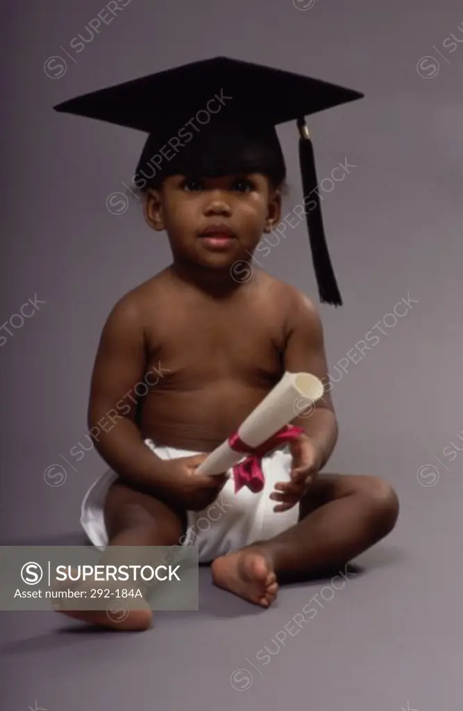 Baby wearing a mortar board and holding a diploma