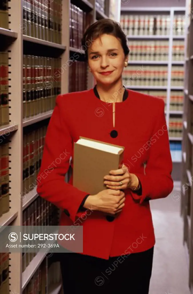 Female lawyer holding a book and grinning