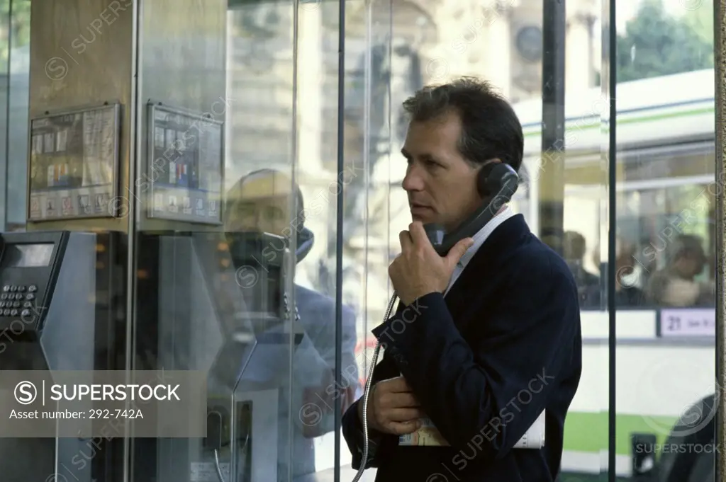 Businessman talking on a pay phone at a telephone booth