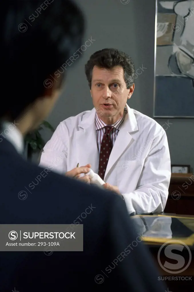 Male doctor explaining medication to a patient in a doctor's office
