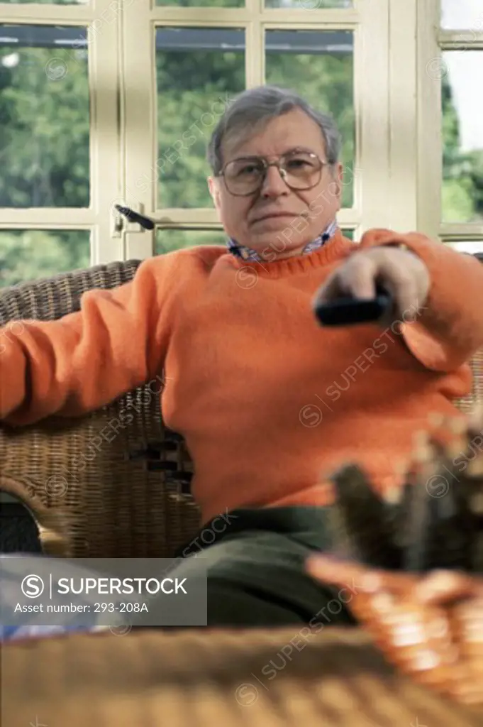 Senior man sitting in an armchair and watching television