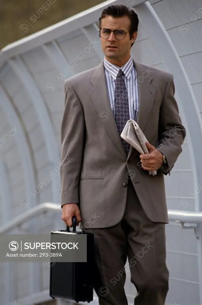 Portrait of a businessman holding a briefcase and newspaper