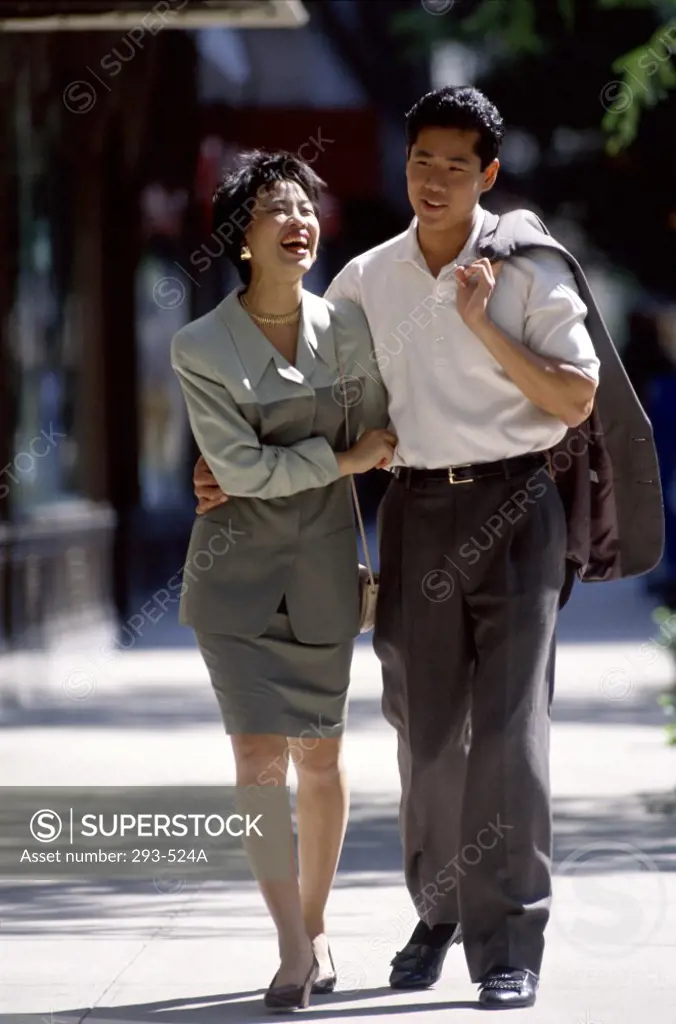 Young couple walking on a sidewalk and smiling