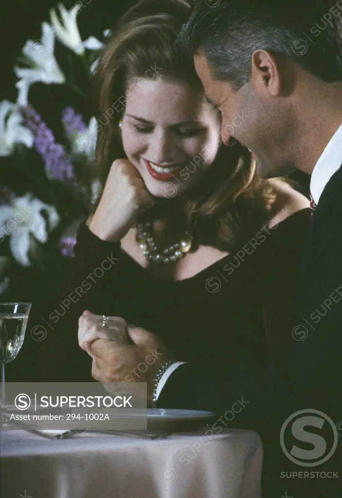 Mid adult couple looking at an engagement ring and smiling