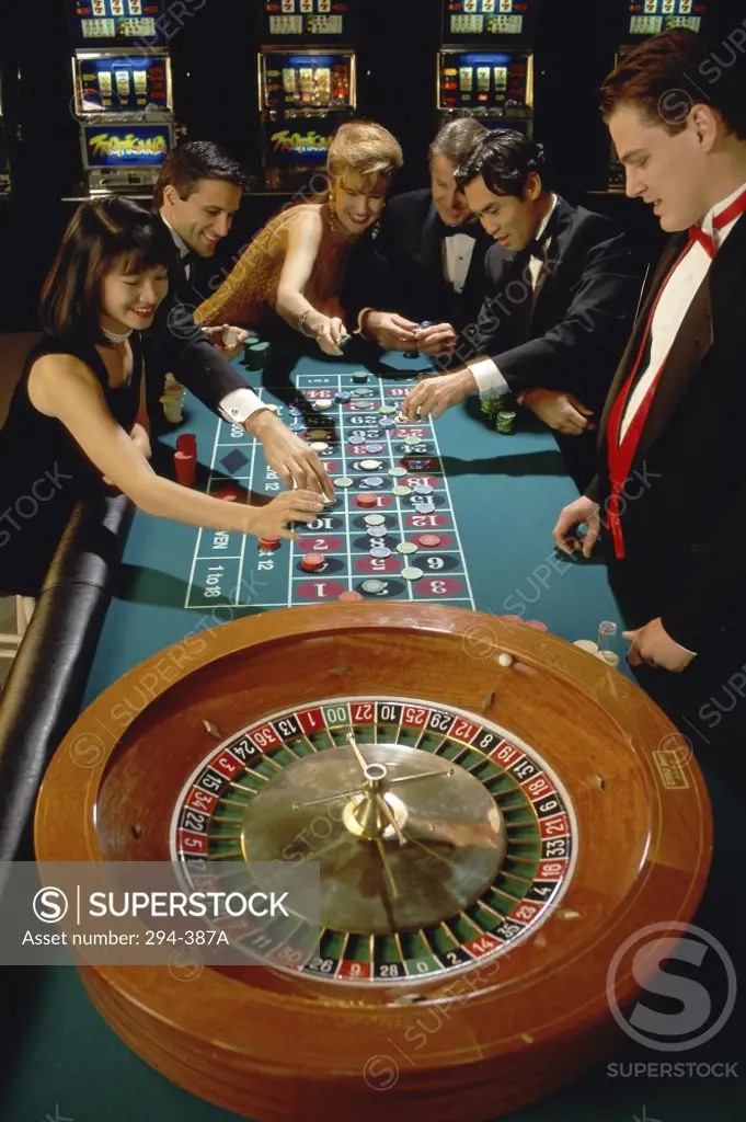 Group of people playing at a roulette table in a casino