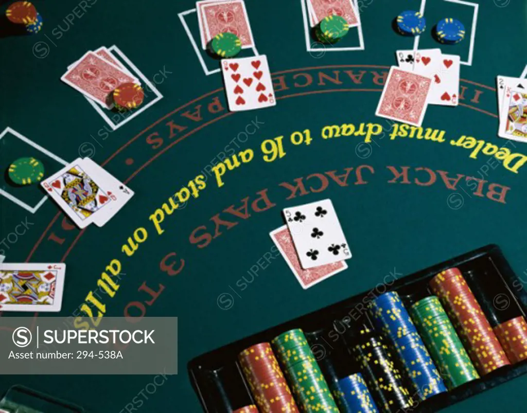 High angle view of playing cards with gambling chips on a blackjack table