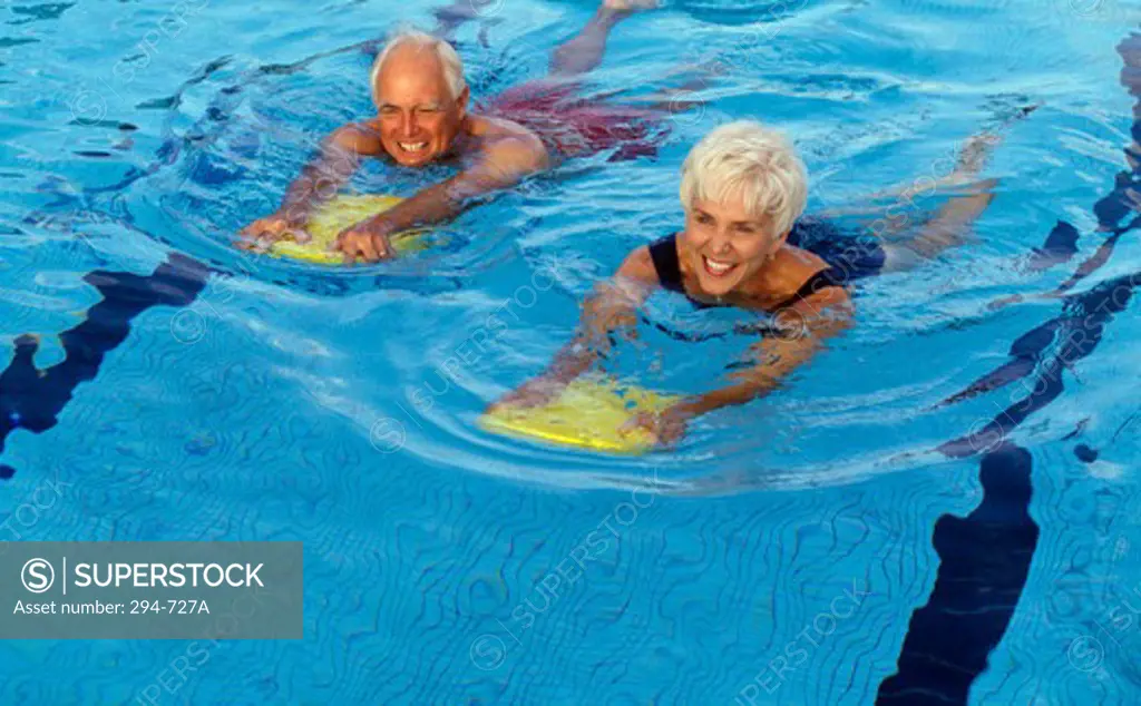 Senior couple swimming in swimming pool