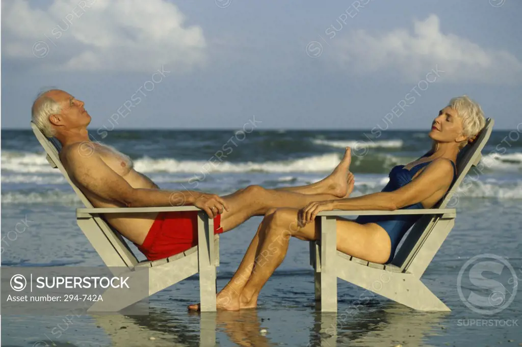 Senior couple sitting in Adirondack chairs