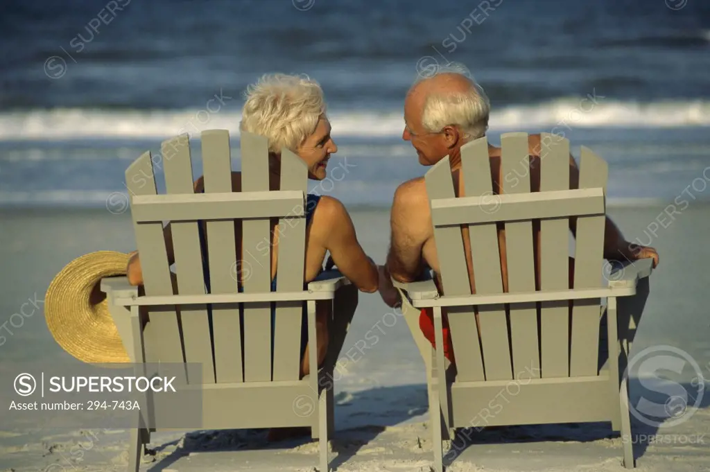 Rear view of a senior couple sitting in Adirondack chairs
