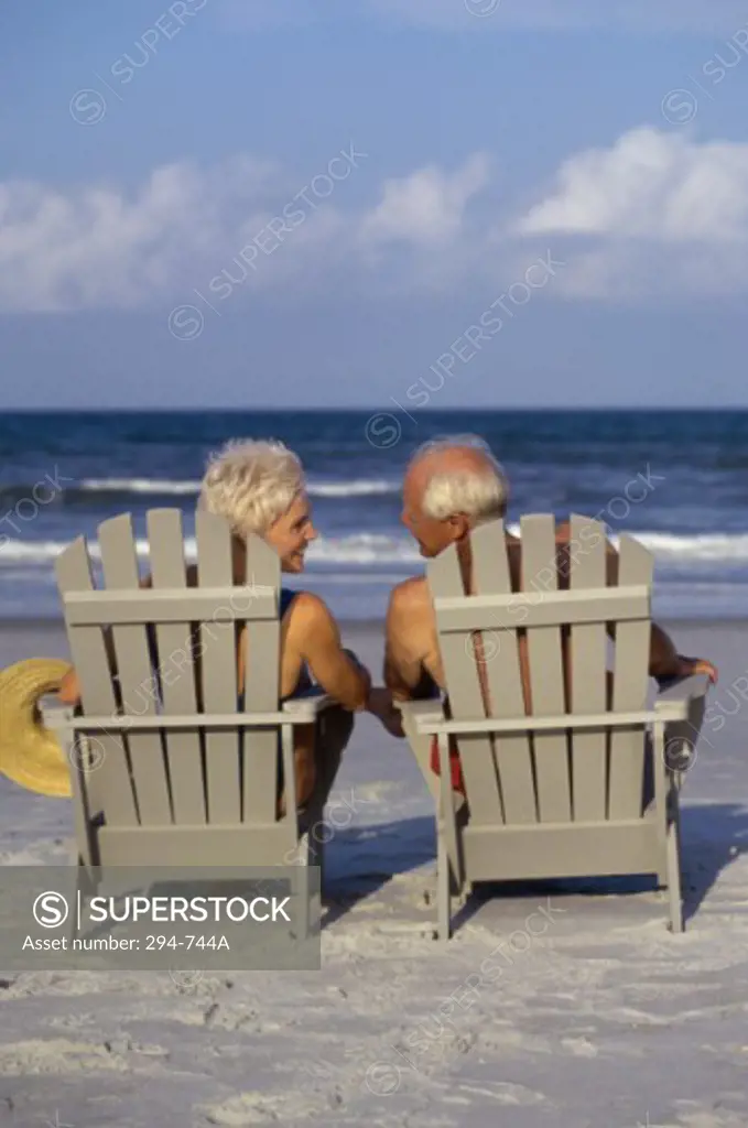 Rear view of a senior couple sitting in Adirondack chairs