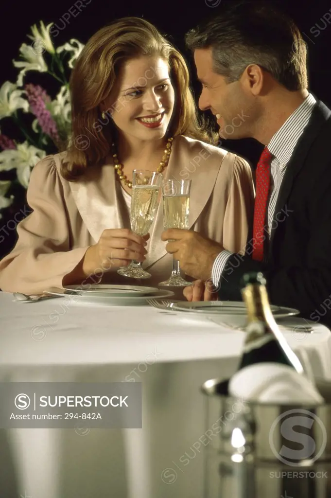 Mid adult couple toasting with champagne in a restaurant
