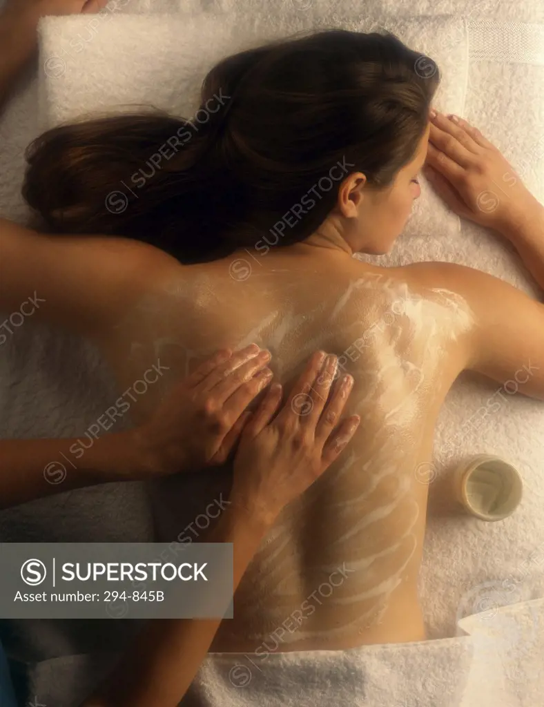 Rear view of a young woman receiving a back massage from a massage therapist