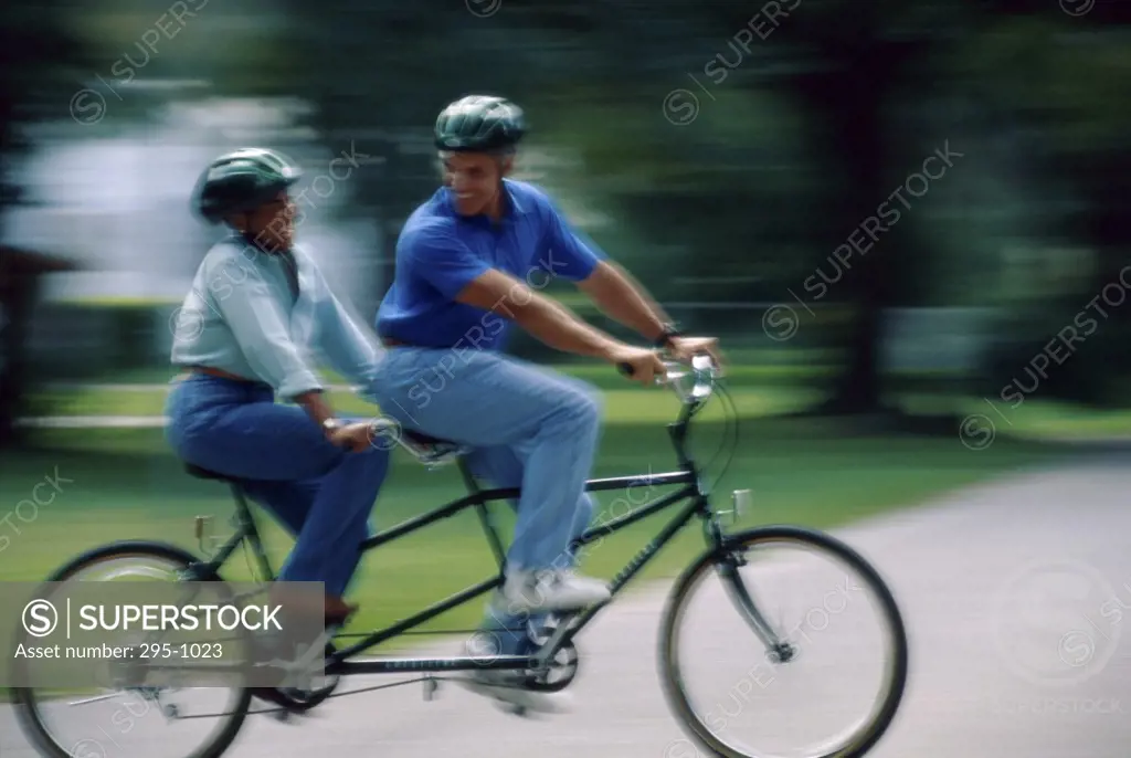 Mature couple riding a tandem bicycle