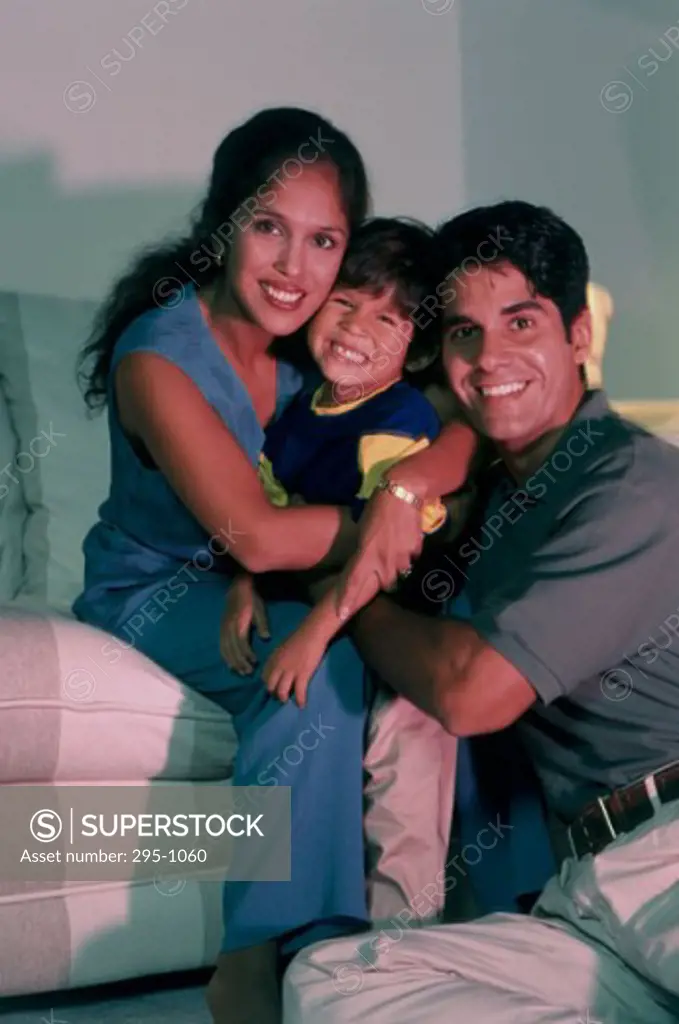 Portrait of a mid adult couple hugging their son and smiling