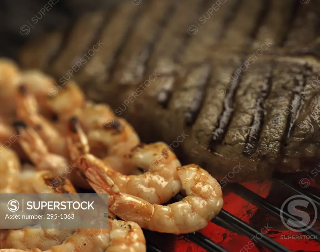 Close-up of shrimp and a steak on a barbecue grill