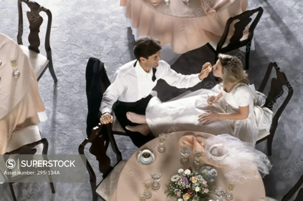 High angle view of a groom feeding cake to a bride