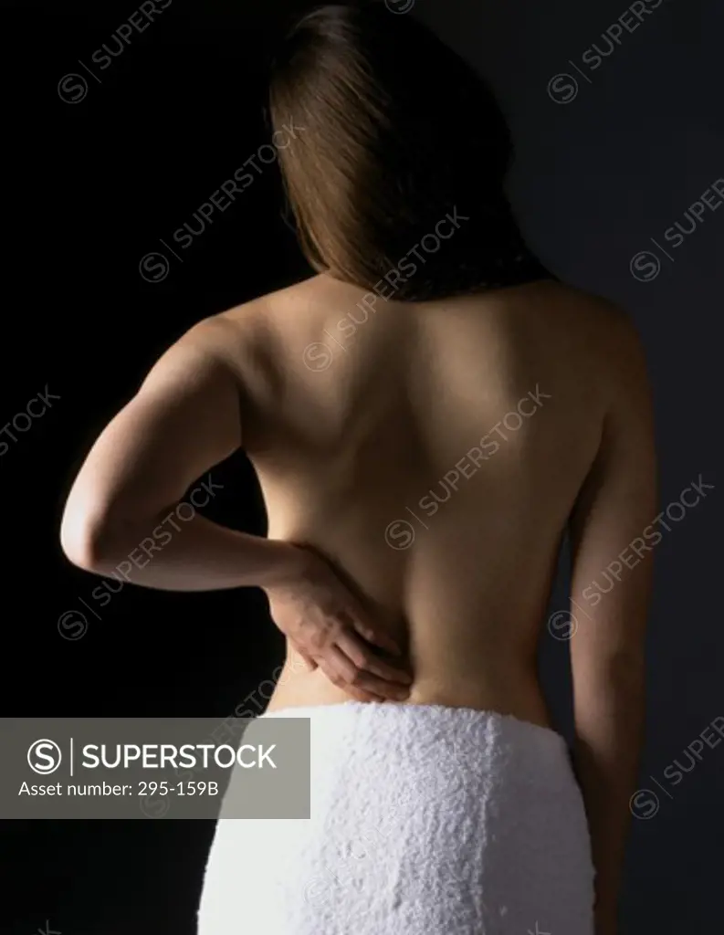 Rear view of a young woman suffering from a backache