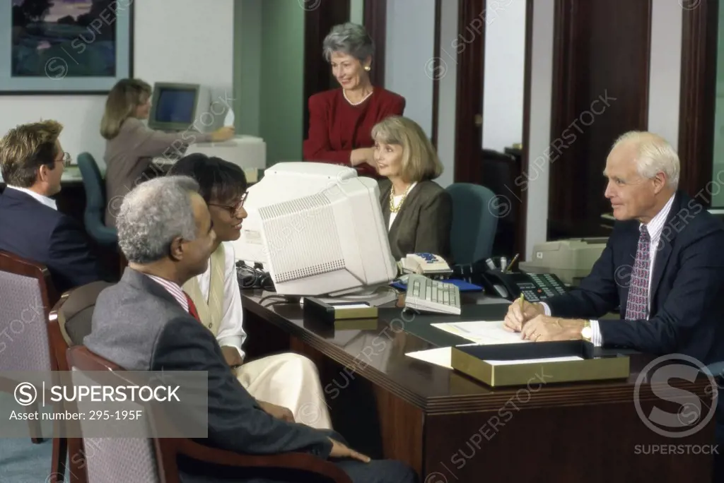 Financial advisor talking with a mature couple in a bank