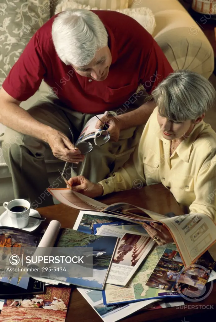 High angle view of a senior couple reading a travel guidebook