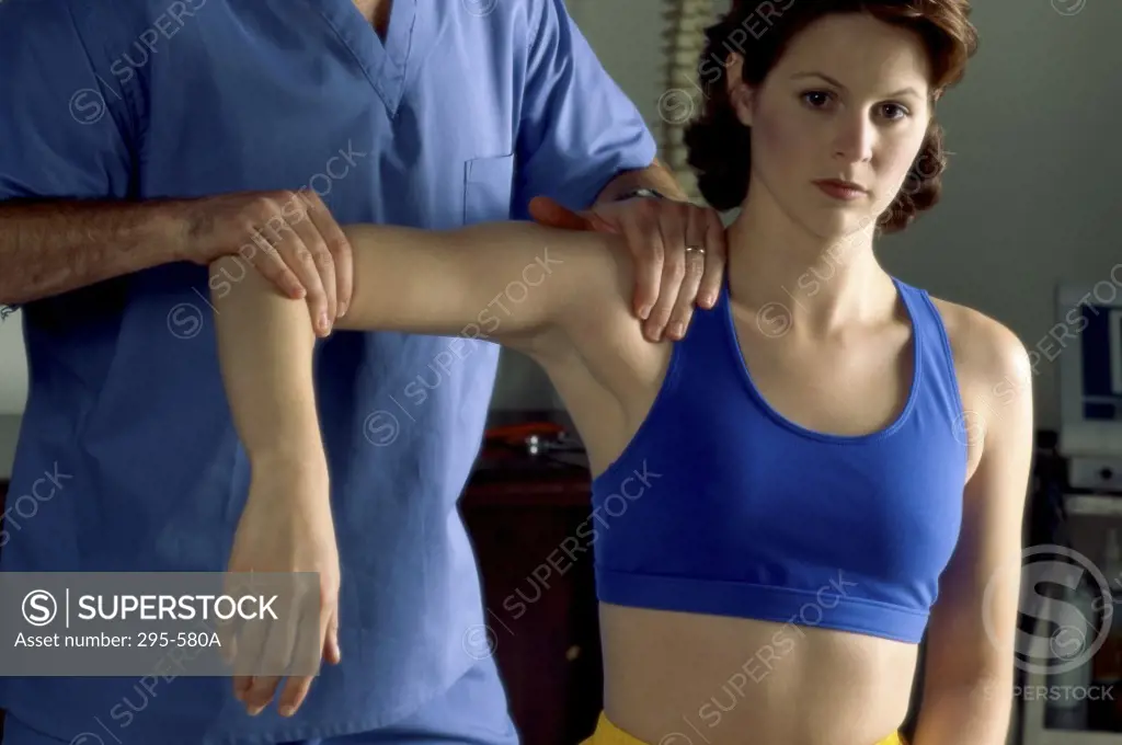 Mid section view of a chiropractor examining a female patient in a doctor's office