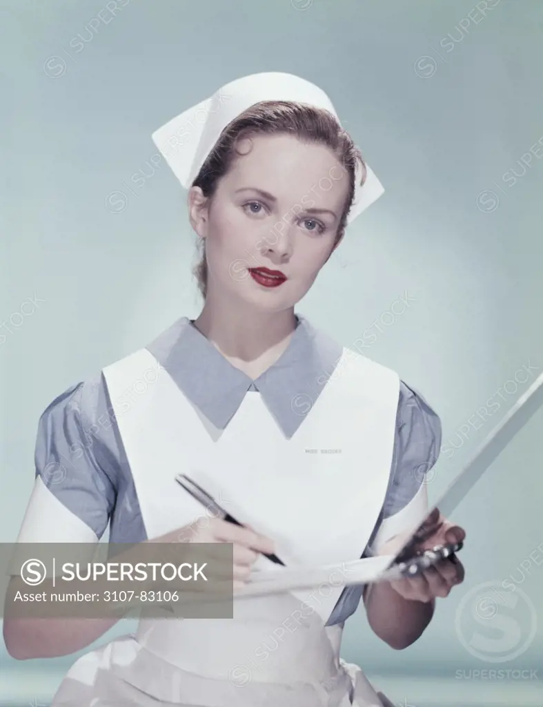 Close-up of a nurse writing on a clipboard