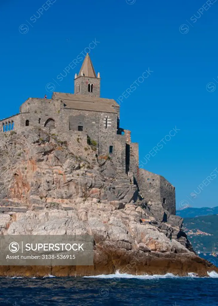 Low angle view of a church and a castle on the coast, Church of San Pietro, Doria Castle, Portovenere, La Spezia Province, Liguria, Italy