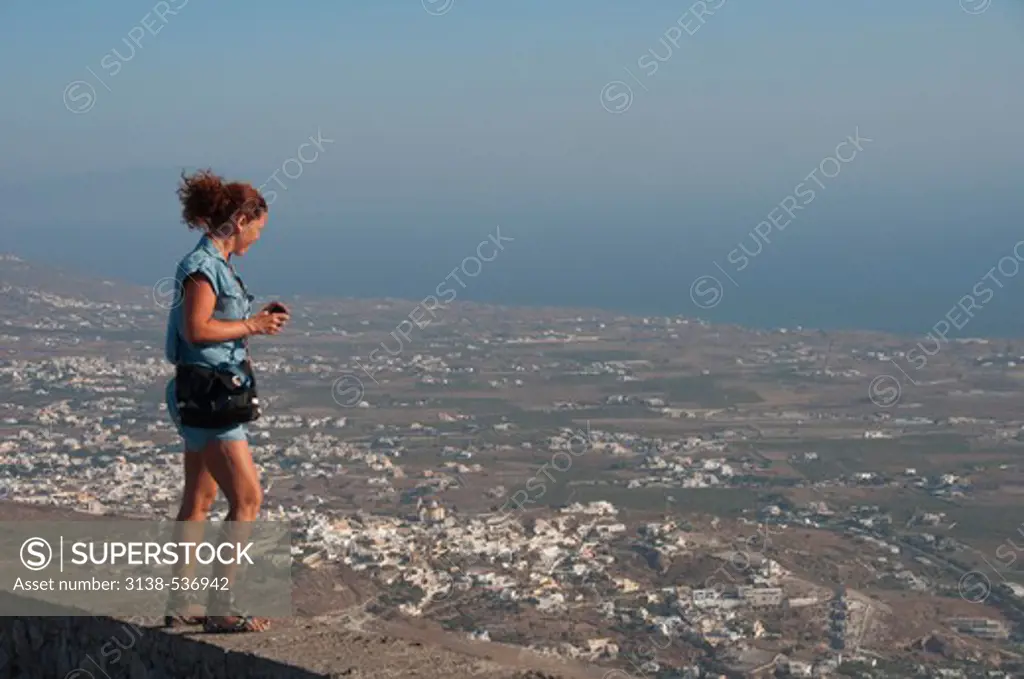 Woman looking out over island, Santorini, Greece