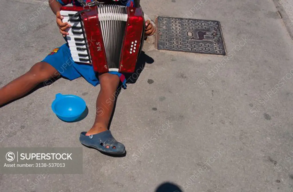 Boy playing accordion and begging on a street, Rhodes, Dodecanese Islands, Greece