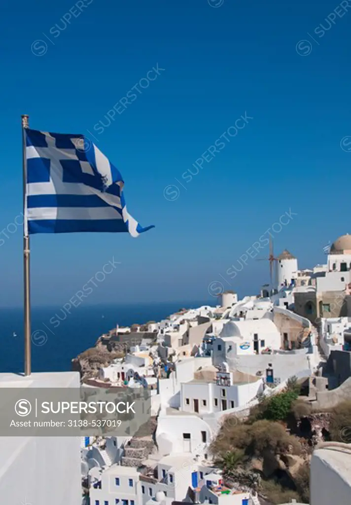 Greek flag with a town at the waterfront, Santorini, Cyclades Islands, Greece