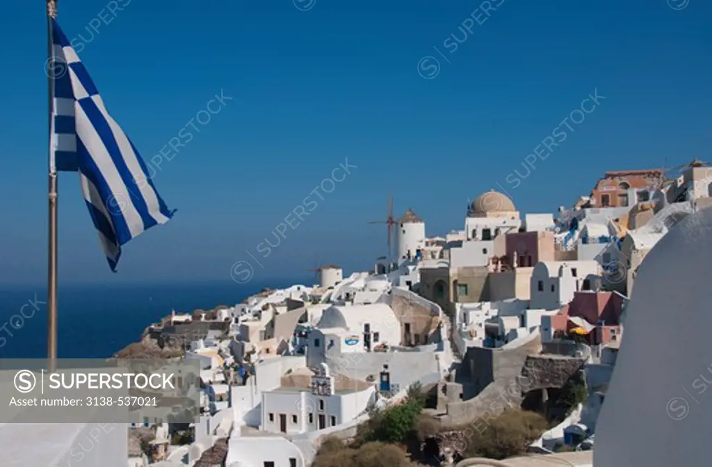Greek flag with a town at the waterfront, Santorini, Cyclades Islands, Greece