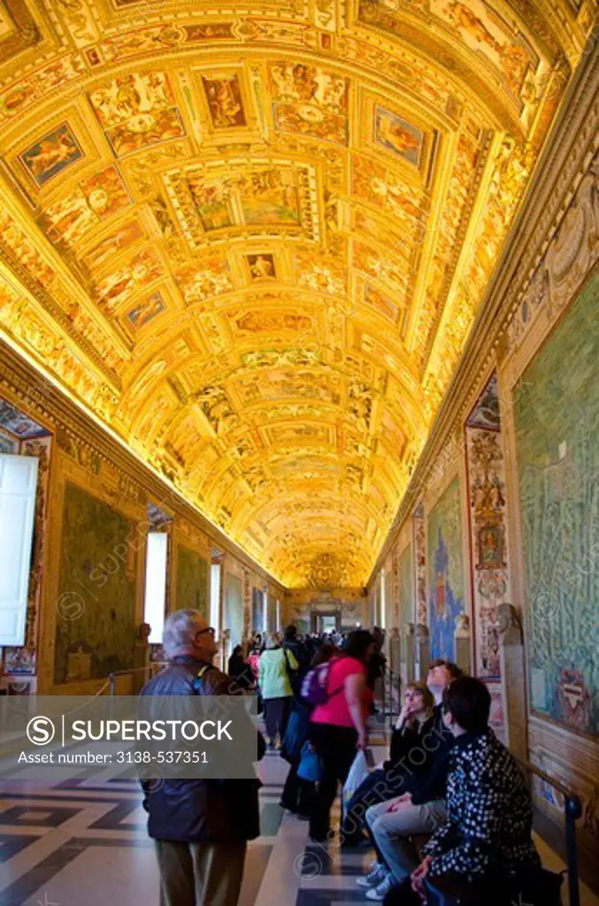 Tourists contemplate ceiling of the Gallery of Maps, Vatican Museums, Vatican City