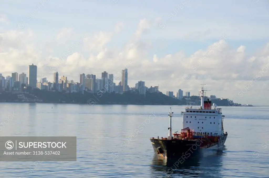 Oil tanker on a tugboat with skyscrapers in the background, Salvador, Bahia, Brazil