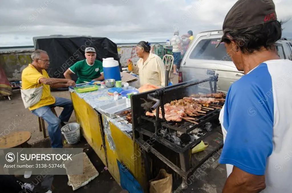 Three men enjoying food on a street, Manaus, Amazonas, Brazil