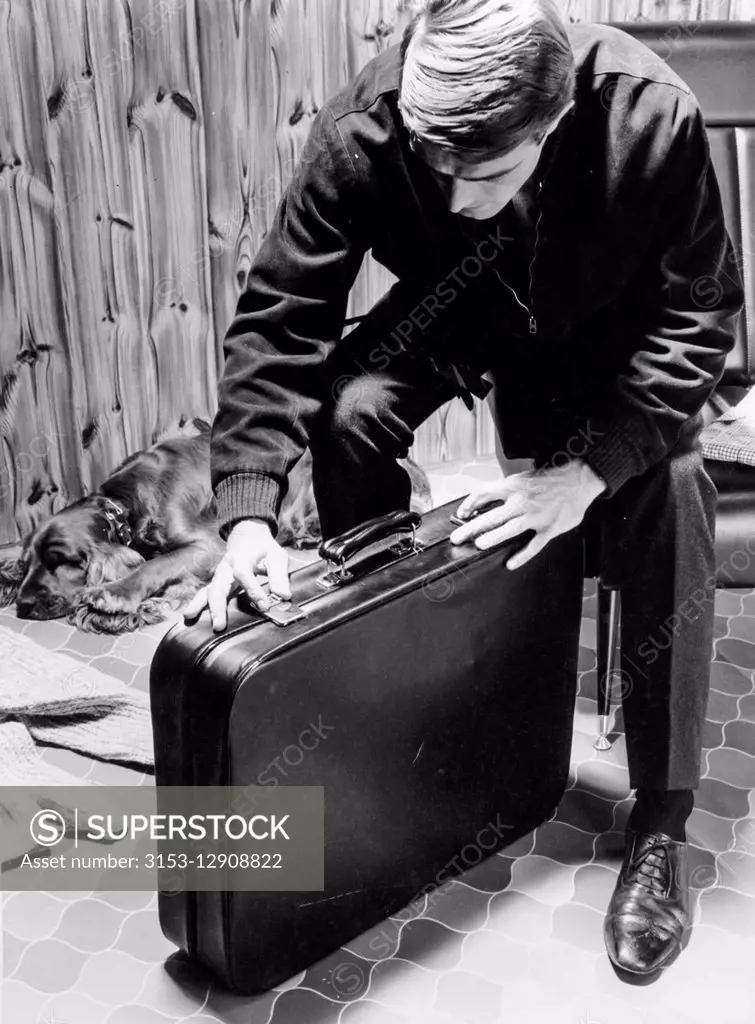 a man closes a briefcase, 1965