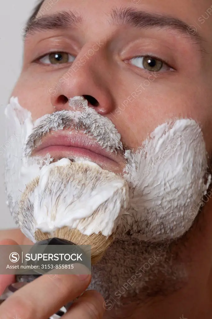 young man apply shaving cream on the face