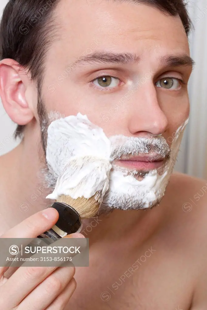 young man apply shaving cream on the face