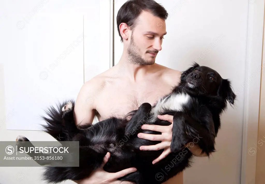 un uomo tiene in braccio un cane