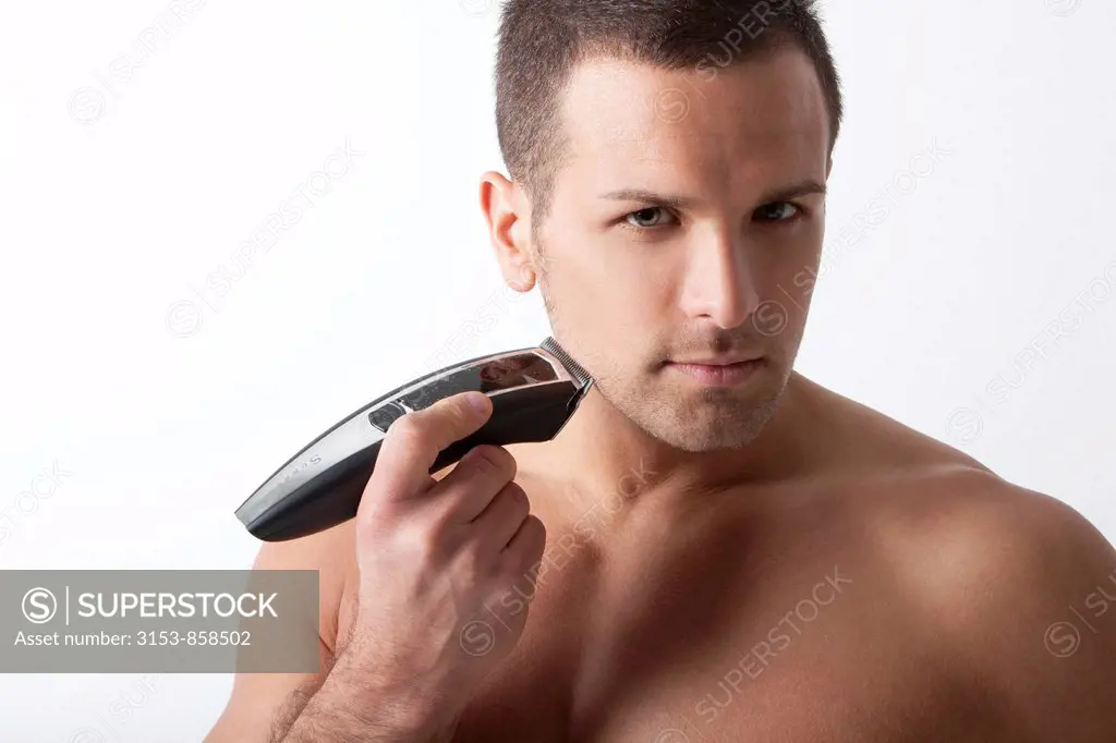 uomo si rade la barba con rasoio elettrico