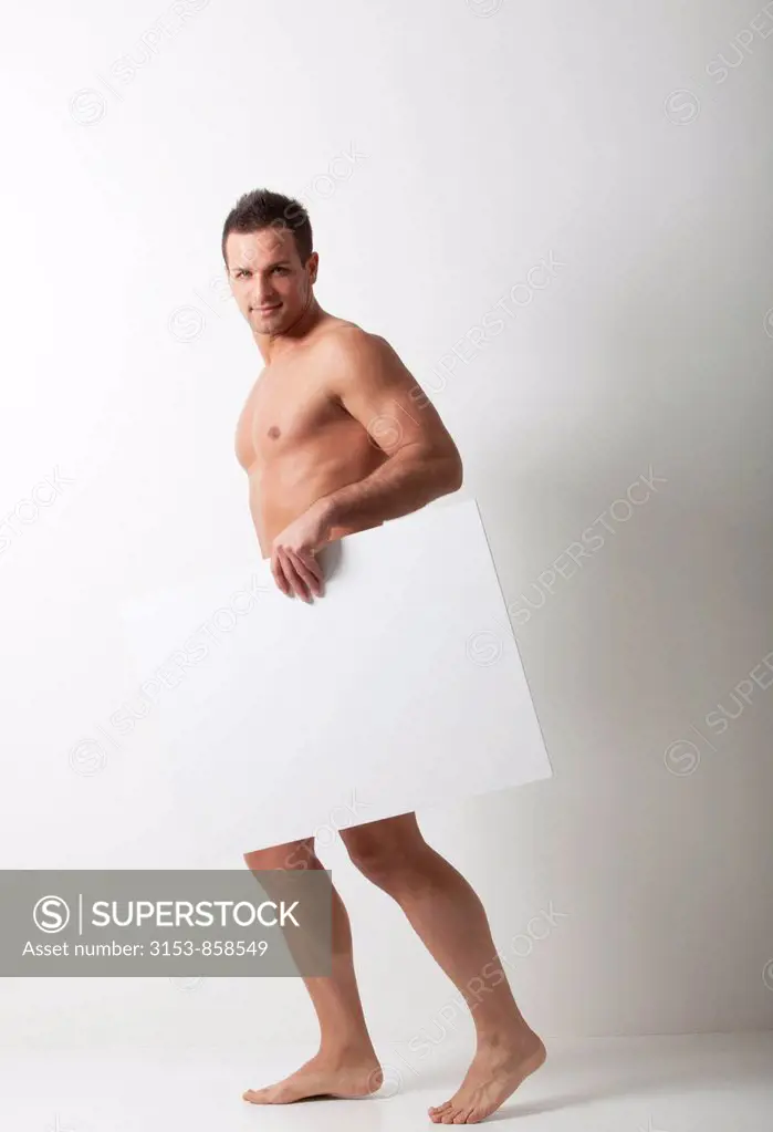 uomo nudo dietro ad un pannello bianco