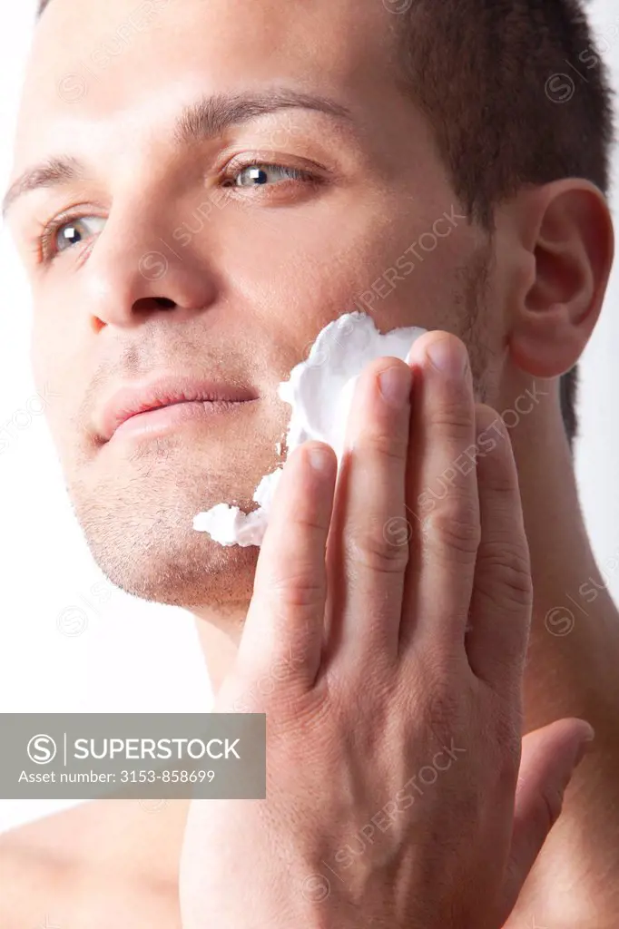 uomo applica la schiuma da barba sul viso