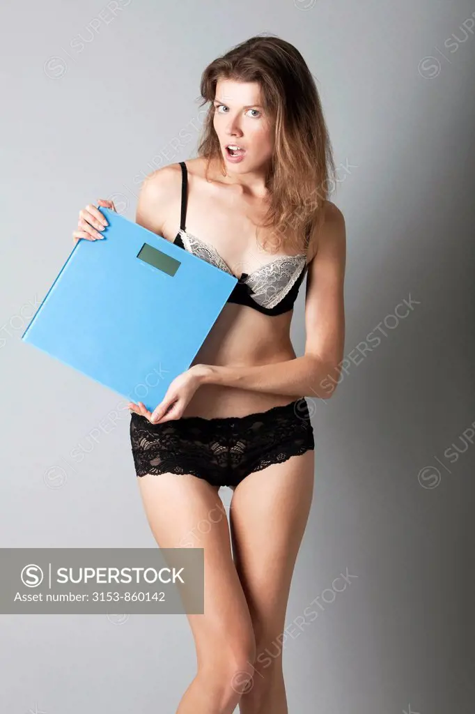 giovane donna in lingerie con bilancia