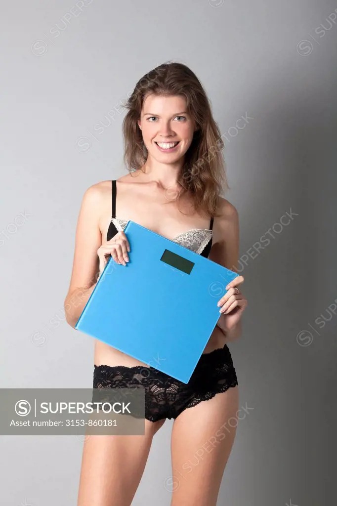 giovane donna in lingerie con bilancia